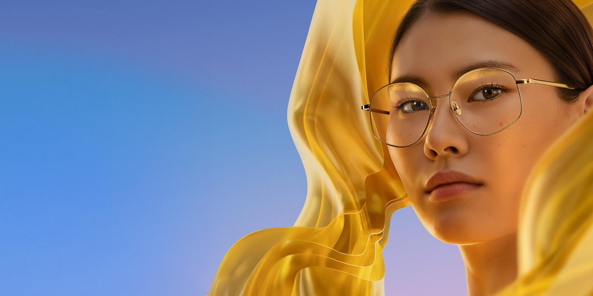 En kvinne bruker klare briller med ZEISS DuraVision Gold UV, som gir brilleglassene en diskré og samtidig særpreget gyllen refleks.