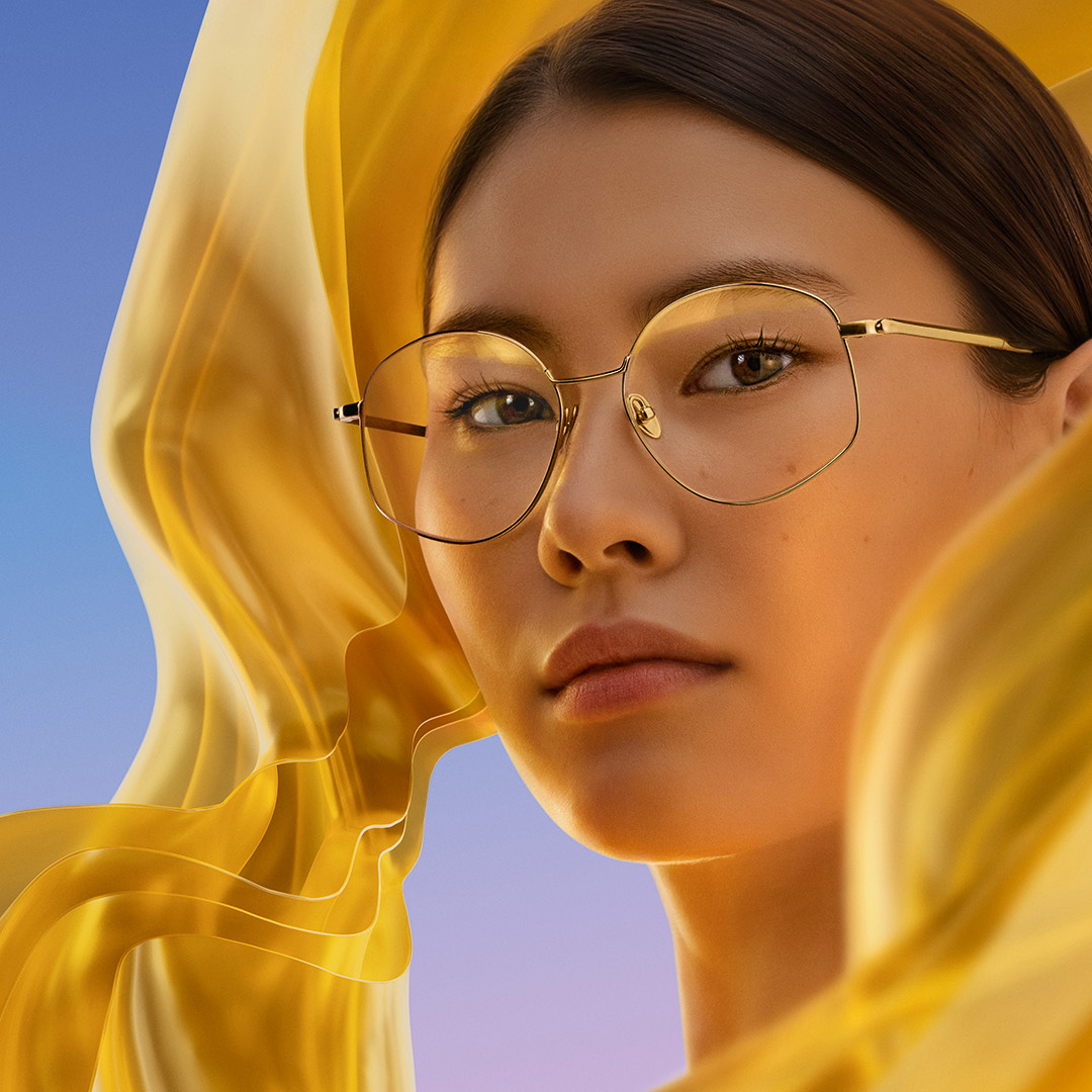 Kvinne som bruker briller med ZEISS DuraVision Gold UV antirefleksoverflatebehandling som viser glassets diskré gylne reflekser.