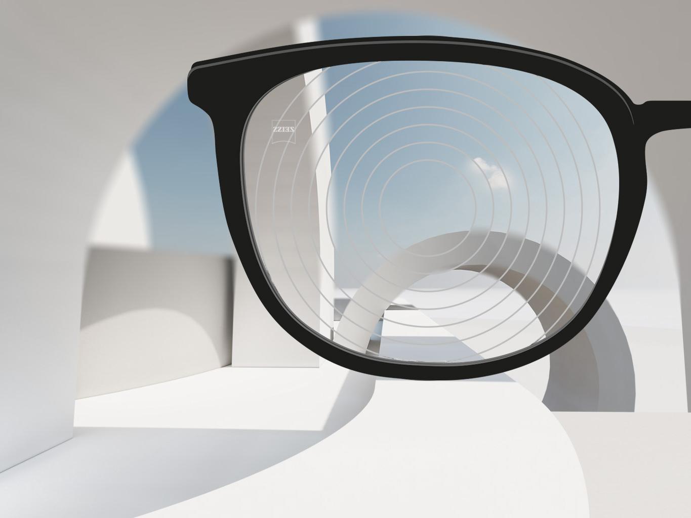 Et nærbilde av brilleglass for nærsynthet fra ZEISS, med svarte brilleinnfatninger og konsentriske sirkler på brilleglassoverflaten. 