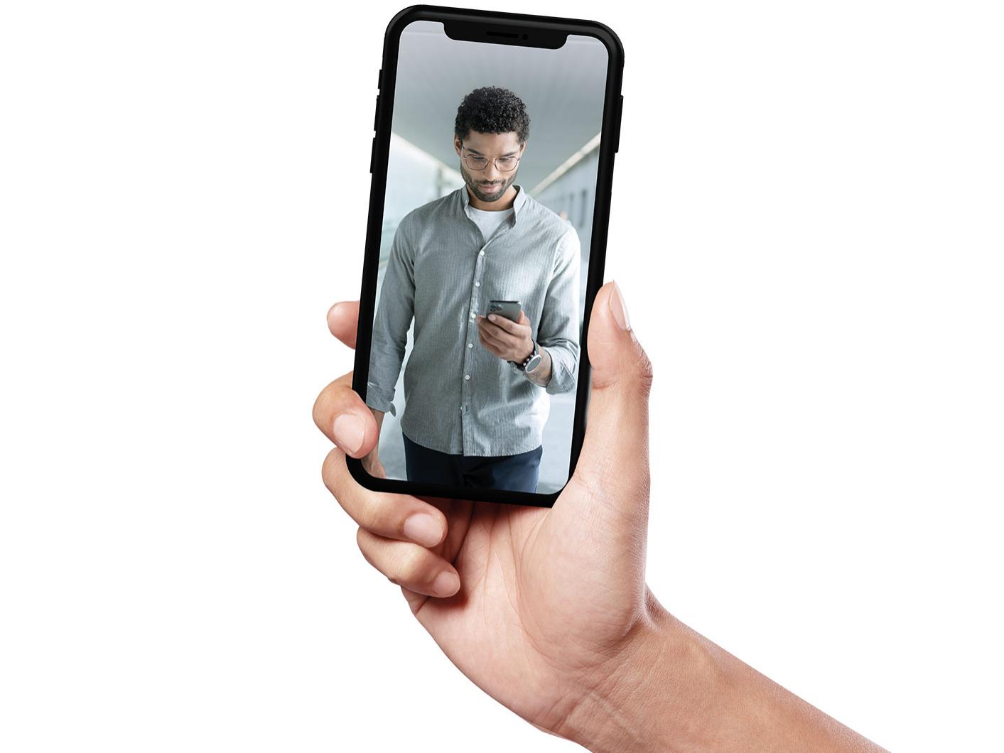 Smarttelefon som viser en ung mann med kort hår som går og har på seg ZEISS SmartLife-glass.