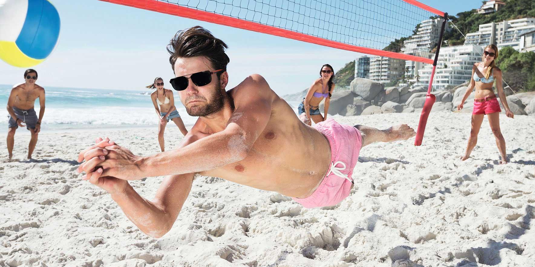 Mennesker på stranden som spiller strandvolleyball