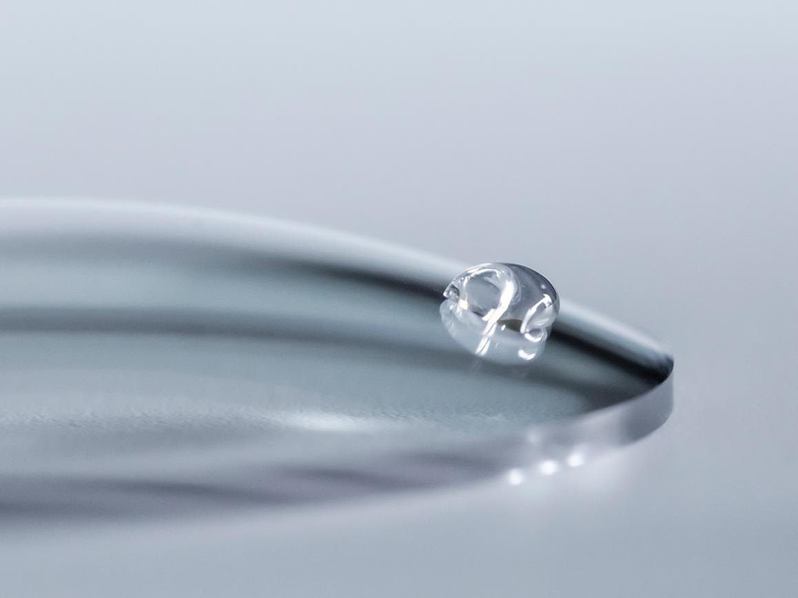 En vanndråpe glir av et ZEISS-glass med et enkelt renhetsbelegg.