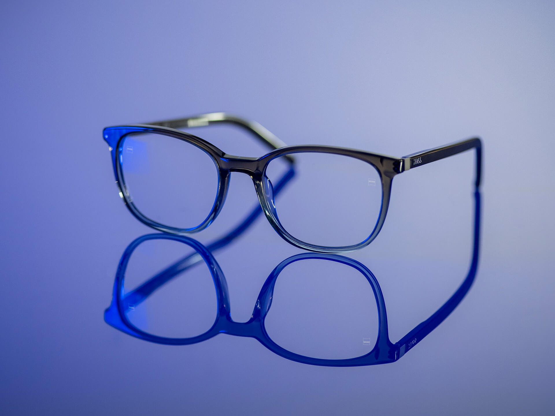 Briller som kan ses i blåaktig lys og har ZEISS-glass med BlueGuard-glassmateriale. Bare en svært redusert blålig refleksjon er synlig på glassene.