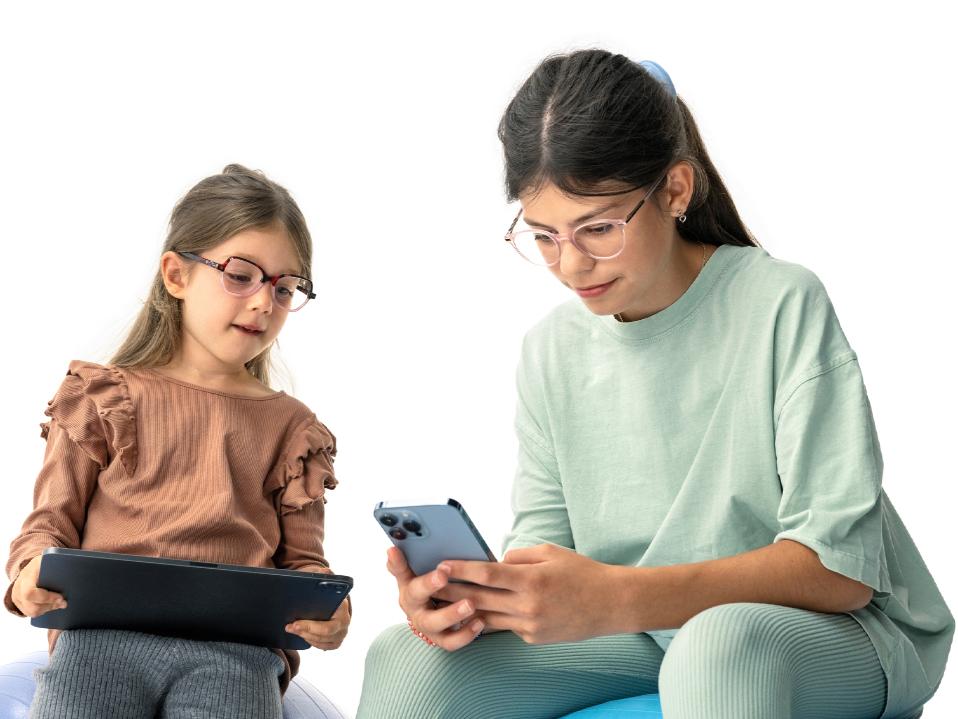 To jenter ser på digitale enheter i den foreslåtte avstanden på mer enn 20 cm.