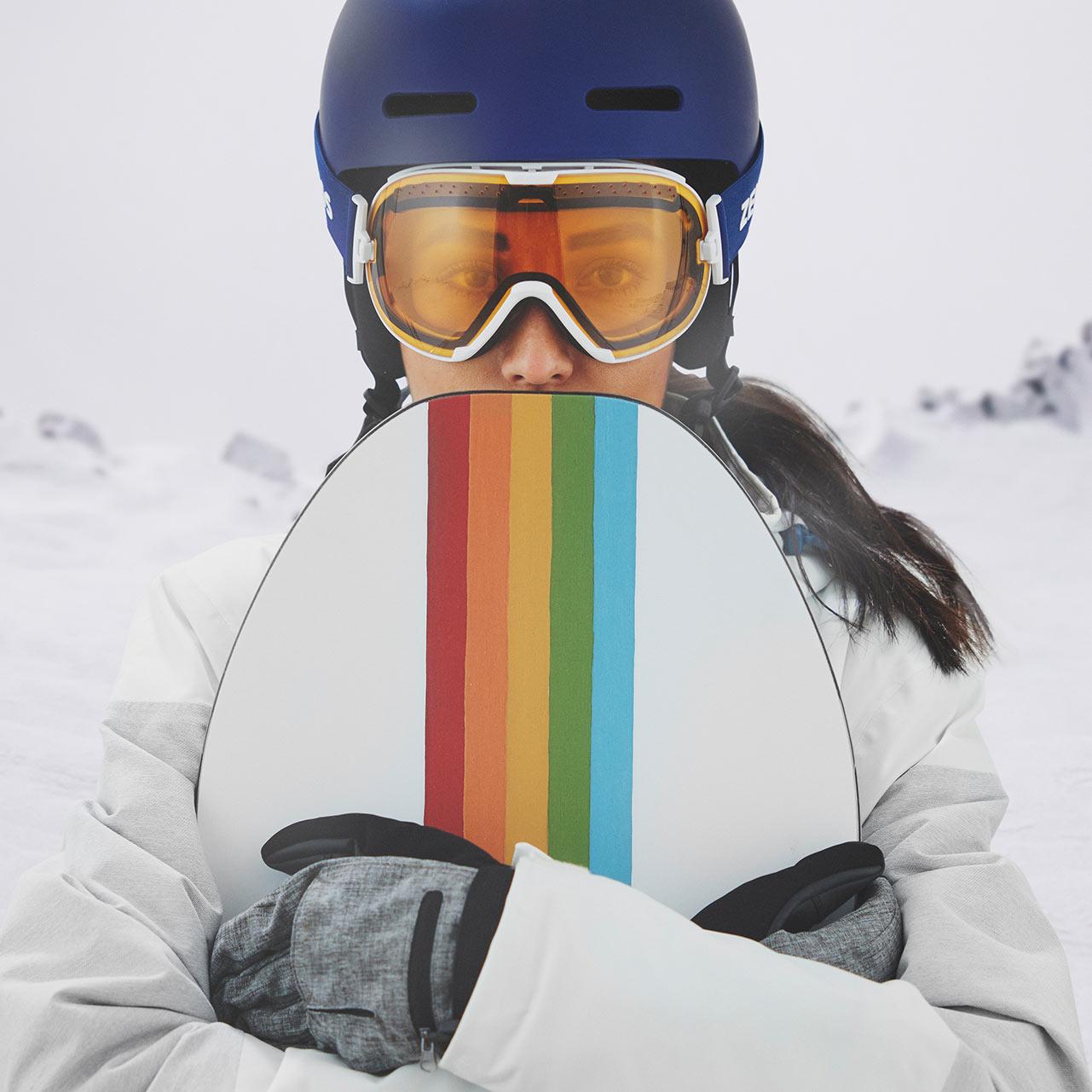 En kvinne bruker en blå hjelm og ZEISS skibriller med gjennomsiktig visir.