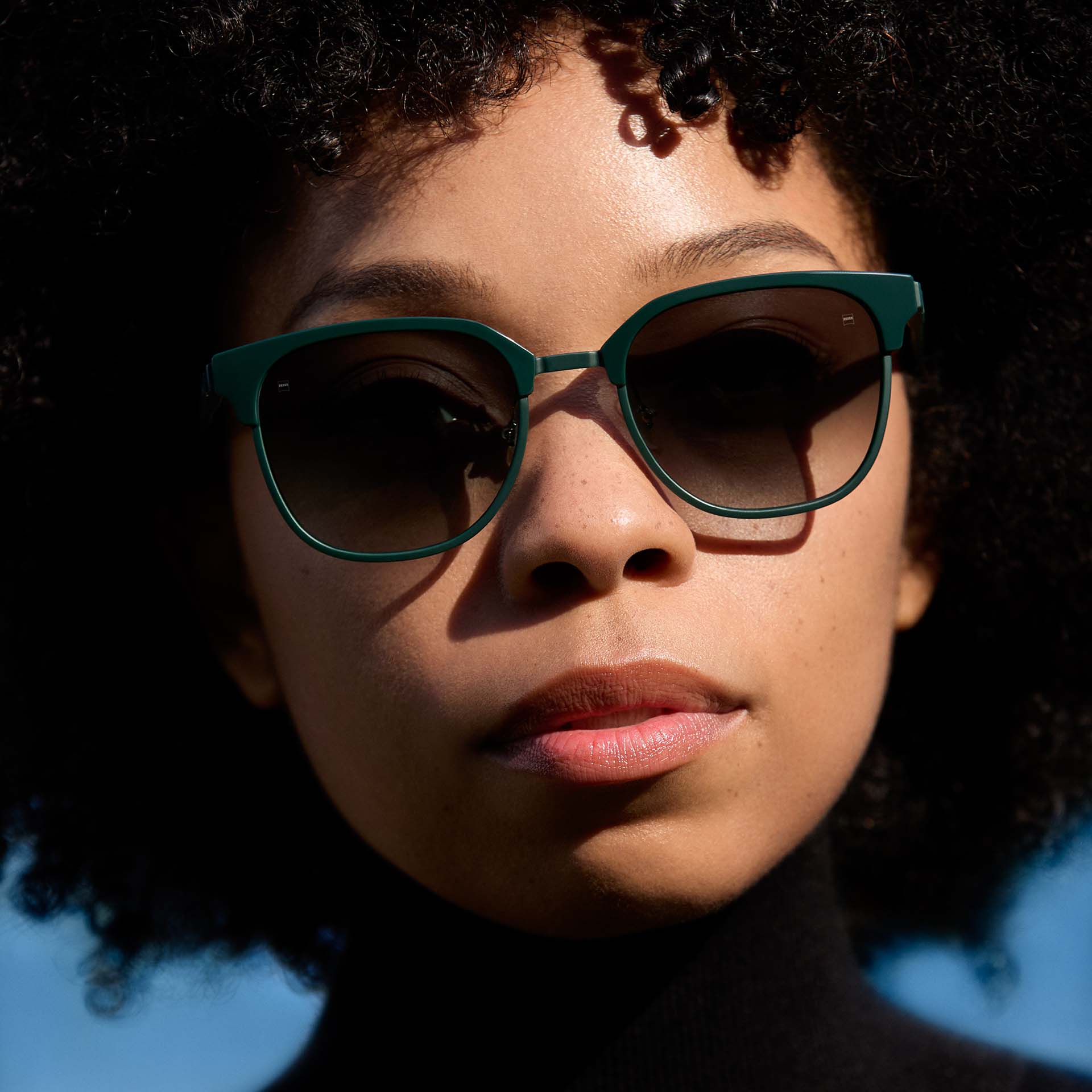 En kvinne som bruker grønne innfatninger med graderte glass. 