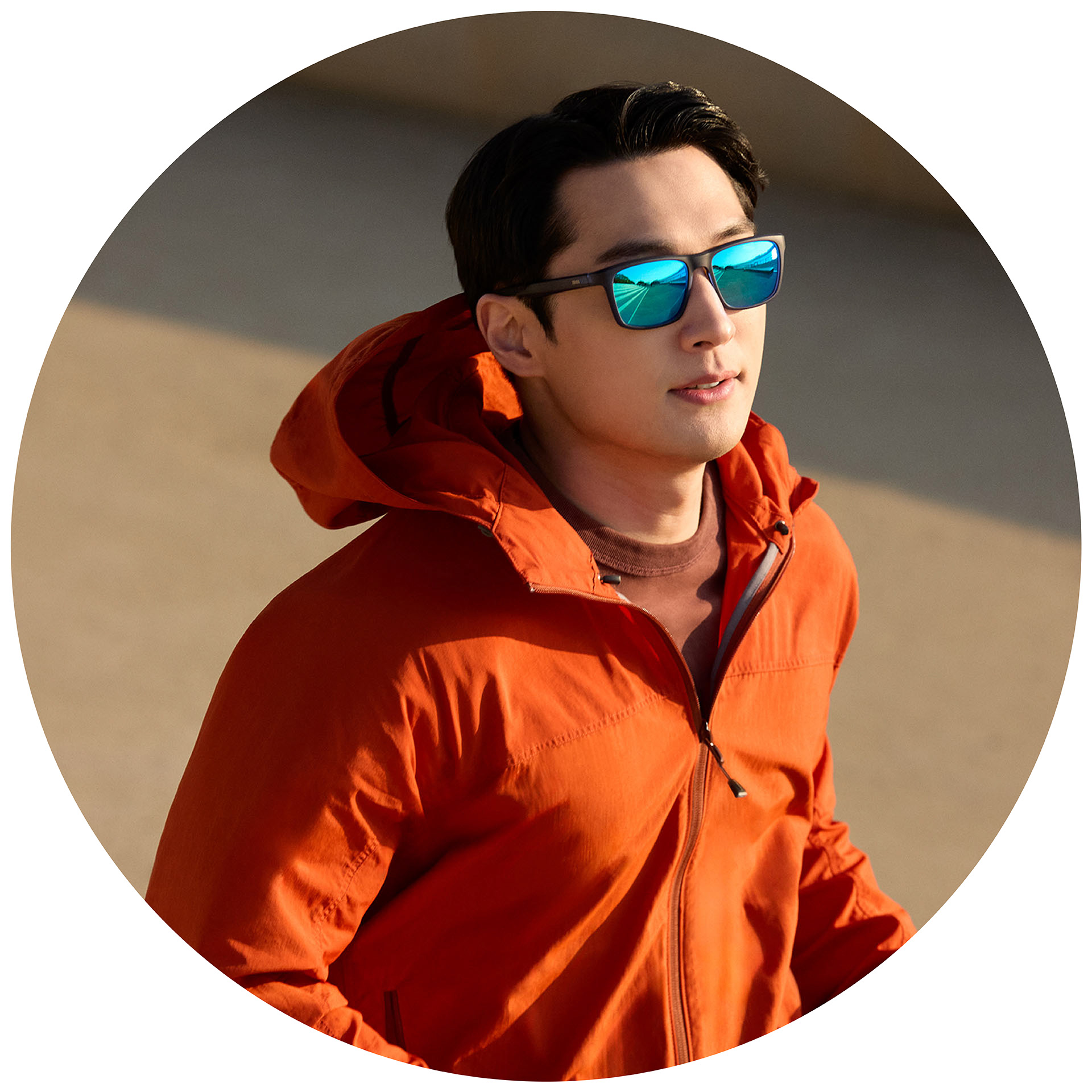 En jogger i en oransje jakke som bruker ZEISS solbriller med styrke med blå speilglass.