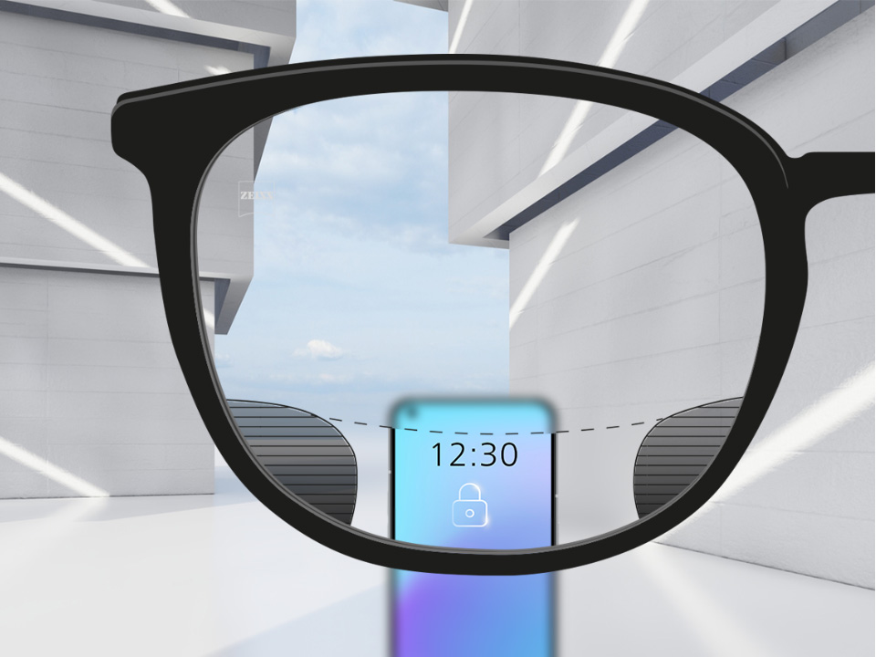 Et perspektivbilde med ZEISS Digital SmartLife-glass med en smarttelefon og glasset som er helt klar på det øvre og nedre området av glasset og små uskarpe plott til venstre og høyre. 