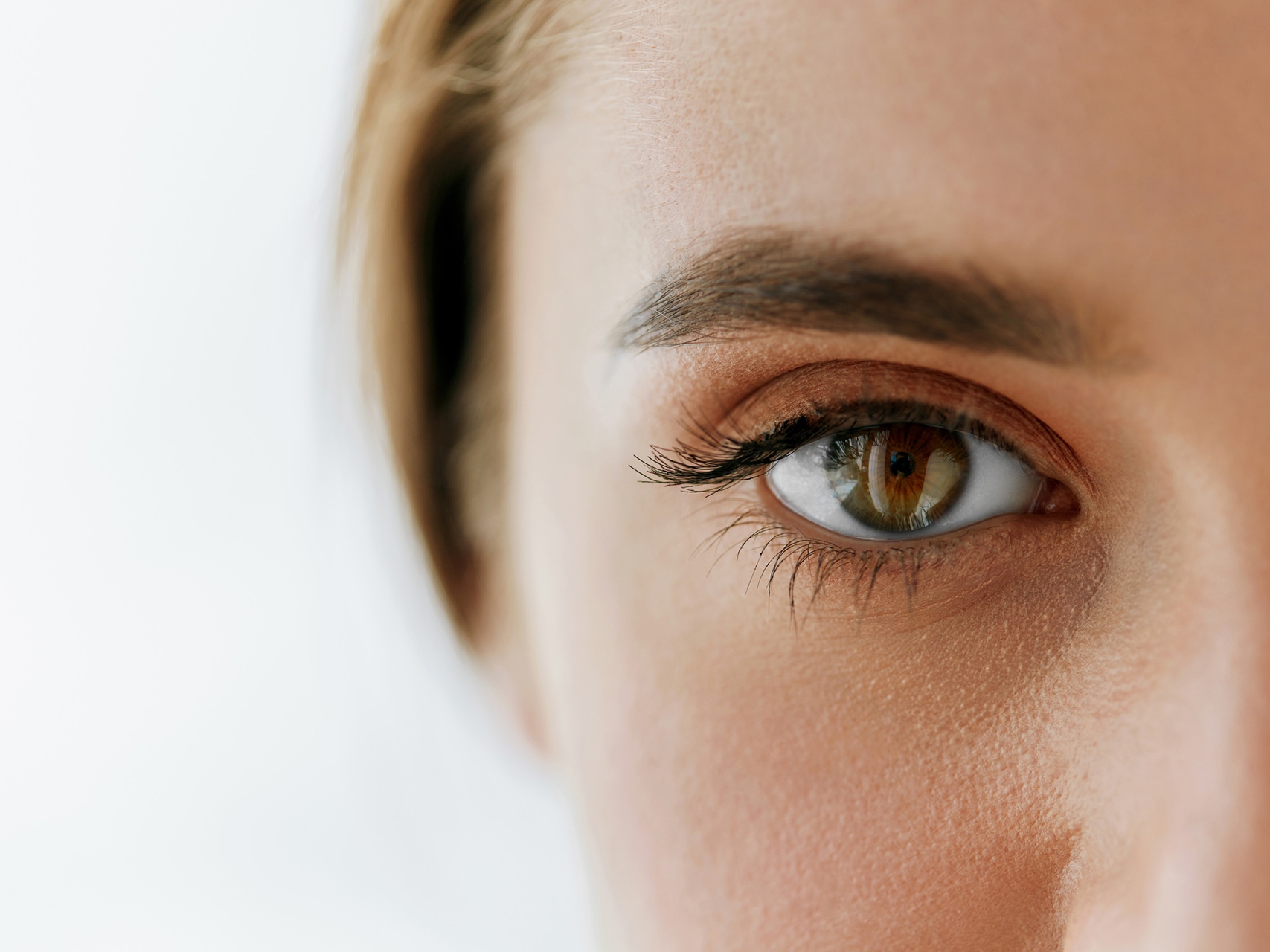 Bildet viser et nærbilde av en kvinnes ansikt, med fokus på venstre øye. 