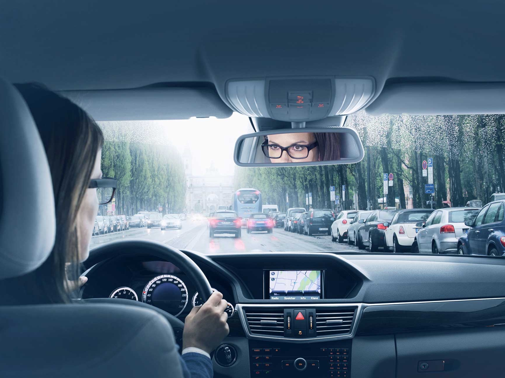 Et bilde av et bilinteriør med en kvinne som sitter i førersetet. 