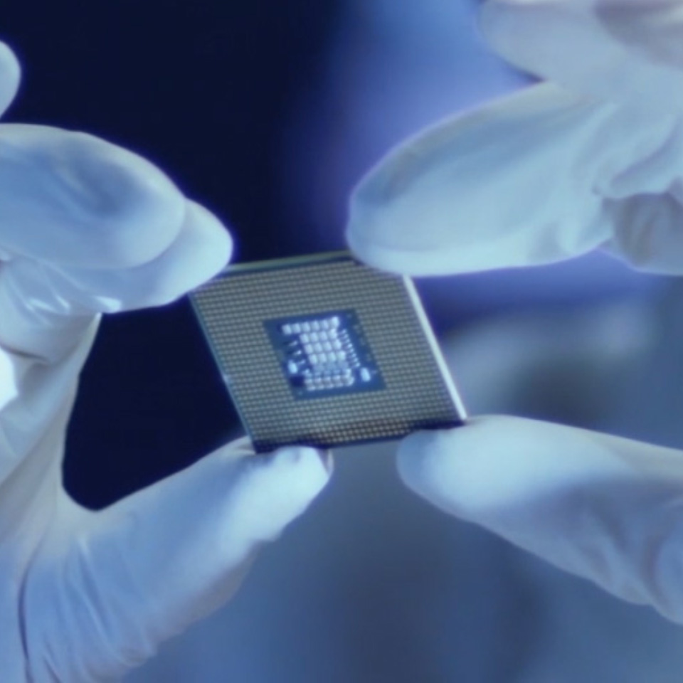 Et bilde av en mikrobrikke holdt av en person med laboratoriehansker. 
