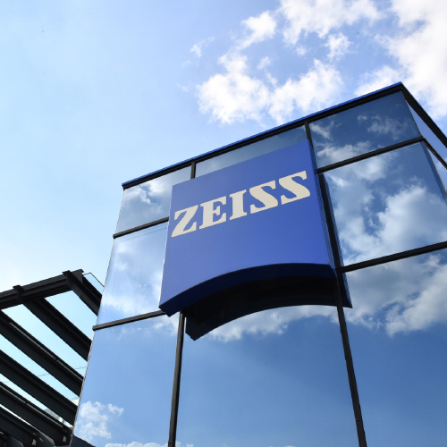 Et bilde av en moderne glassbygning med en stor ZEISS-logo på. 