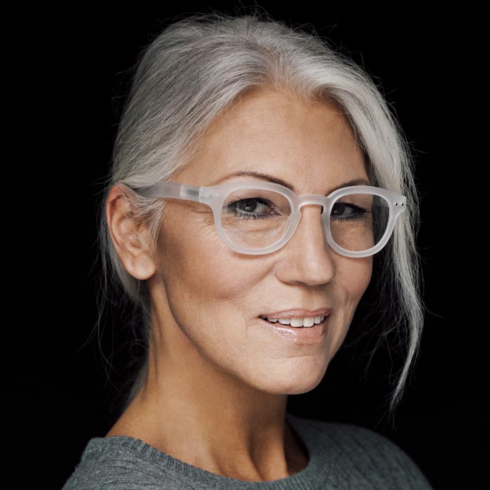 Kvinne med grått hår med hvit innfatning med ZEISS SmartLife Progressive glass. Geometrisk ansiktsskanning som viser ansiktsanatomi- og innfatningsmålinger.